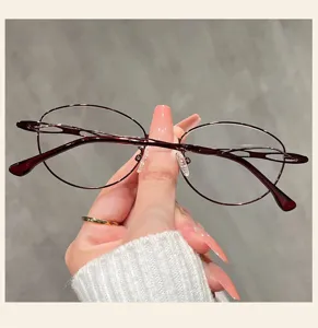Close-up detail of stylish dark red oval eyeglass frame, elegant metal texture design.