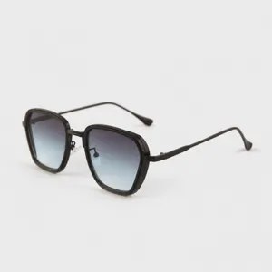Lunettes de soleil tendance avec monture noire épaisse et verres dégradés élégants.