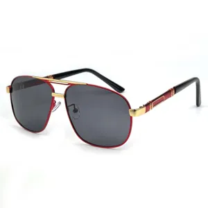 Gros-plan de lunettes de soleil aviateur homme en métal avec monture rouge et double pont.