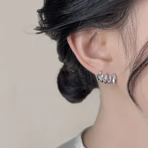 Close-up detail view of the minimalist micro-pave zircon five-claw ear stud jewelry piece.