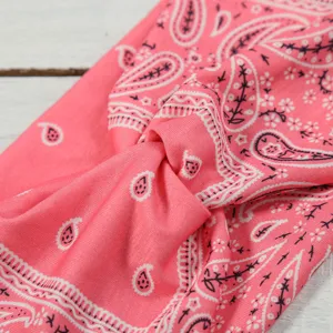 Detailed shot of a pink paisley twist headband, stylish elastic hair band for daily wear.