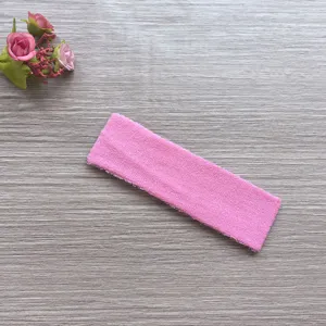 Close-up detail of a soft pink terry cloth sports sweat headband, highly absorbent fitness accessory.