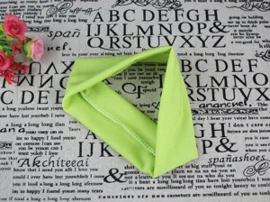 Gros plan détaillé d'un bandeau de yoga extensible vert vif montrant texture et bord.