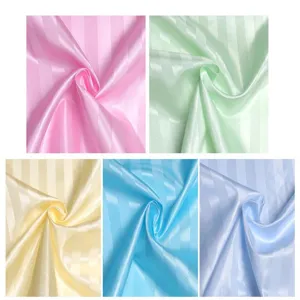 Close up detail showing multiple color options of striped satin fabric, soft glossy texture.