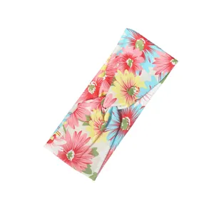 Detailed close-up view of the colorful floral patterned fabric knotted headband texture and print.