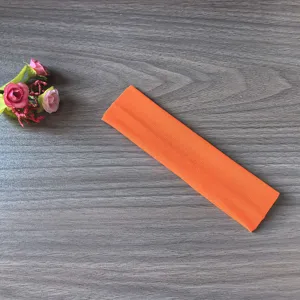 Gros plan détaillé du bandeau de yoga élastique orange vif montrant la texture douce.