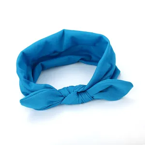 Blue fabric bow headband detail shot, soft material, cute bunny ears hair accessory style.