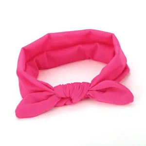 Close-up detail of the bright pink fabric bow headband, featuring soft knot design.