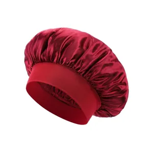 Burgundy satin sleep cap detail showing smooth fabric texture and wide elastic brim for hair care.