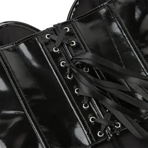 Detail shot of black patent leather corset lacing with metal eyelets and satin ribbon.