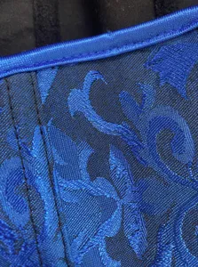 Close-up detail of blue jacquard fabric corset with contrast trim and boning stitching.