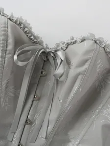 Detailansicht des silbergrauen Damen Korsett Tops mit Jacquard Muster Rüschen und Schleife.