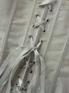 Nahaufnahme eines grauen Jacquard-Korsetts mit Metallösen und Satinschnürung Detail.