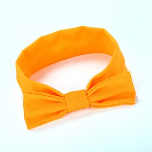 Gedetailleerde close-up van een felle gele stoffen haarband met een mooie strik voor kinderen.