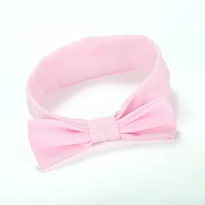 Gedetailleerd overzicht van de roze stoffen strik haarband, zacht materiaal en leuke stijl.