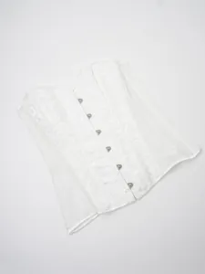 Detail view of a white jacquard lace corset top with front busk closure for women.