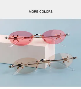 Stylish rimless oval metal sunglasses with cross charms and rhinestones for trendy street wear.