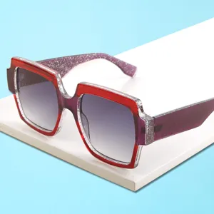 Lunettes de soleil carrées épaisses avec monture pailletée rouge et violet et verres anti-UV.