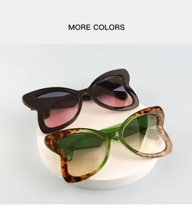 Detailed view of trendy butterfly sunglasses with gradient lenses on a white display podium.