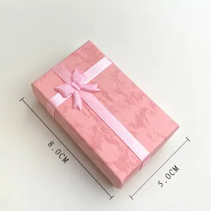 Dettaglio scatola regalo gioielli rosa, piccola confezione rettangolare con grazioso fiocco.