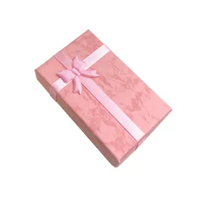 Dettaglio scatola regalo gioielli fiocco rosa, astuccio in cartone per orecchini e anelli.