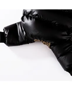 Haustier Winter warme Daunenjacke Detailansicht, schwarzer glänzender Stoff mit Goldmuster.