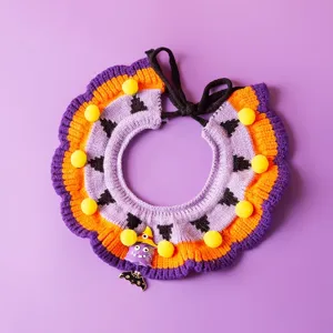 Halloween pet knitted bib detail showing purple orange yarn pom poms and cute witch pendant