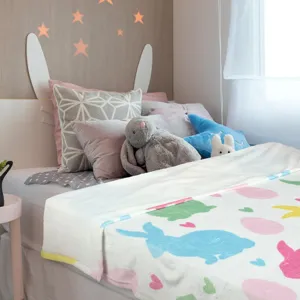 Zachte flanellen deken met kleurrijke paashaas en paasei digitale print voor op het bed.