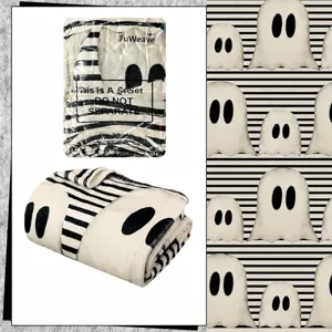 Halloween ghost flannel blanket detail, soft black and white striped throw blanket.