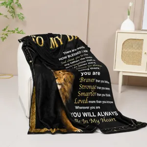 Detailed shot of a cozy black fleece blanket featuring a touching lion graphic and dad message.