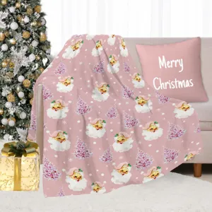 Cozy pink Christmas blanket detail showing soft plush fabric with cute vintage Santa and tree pattern.