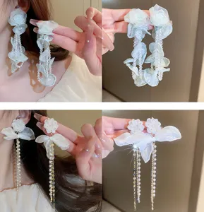 Detailed close-up of fairy-style fabric flower and pearl tassel earrings, showcasing exquisite texture.