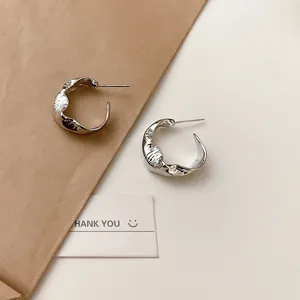 Orecchini a cerchio in metallo argentato minimalista con texture unica per donne chic.