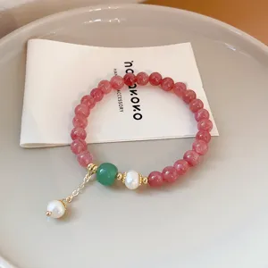 Exquisite beaded bracelet with baroque pearl charm, pink stones and gold accents for chic style.