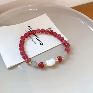 Detailed shot of strawberry quartz bracelet with cute cat pendant and elegant beads for women.