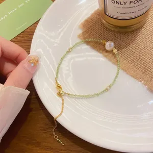 Exquisite details of freshwater pearl and green crystal beaded bracelet with gold chain.