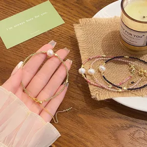 Freshwater pearl crystal beaded bracelet, dainty gold chain style hand jewelry detail.