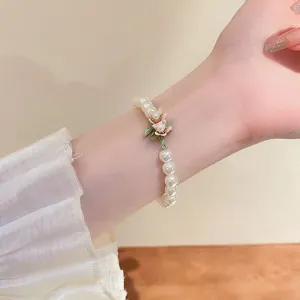 French baroque pearl bracelet with enamel flower charm worn on wrist for women fashion jewelry
