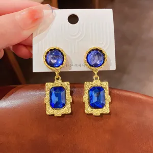 Detailansicht der vintage blauen Strass geometrischen Ohrringe, verziert mit goldem Metallrahmen.