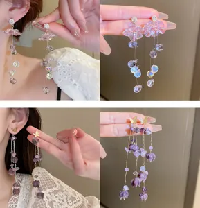 Detail view of long crystal flower butterfly tassel earrings showing sparkling purple stones.