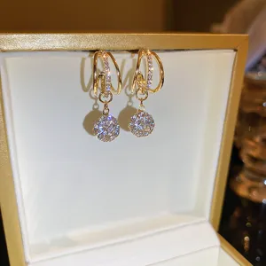 Detail view of elegant gold multi-layer geometric hoop earrings with sparkling zircon balls.