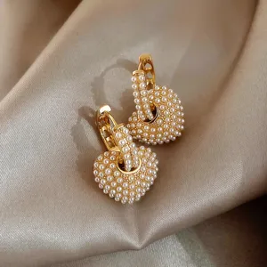 Pearl heart hoop earrings detail shot showcasing delicate beaded texture and gold finish.