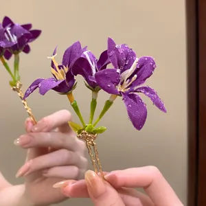 Detail view of a purple fabric flower hairpin, elegant floral hair accessory for women.