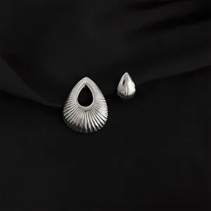 Silver metal waterdrop ear clips close up detail showcasing unique ribbed teardrop jewelry design.