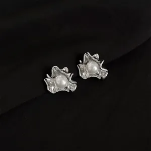 Close up shot of irregular metal pearl ear clips showing exquisite texture and shine.