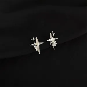 Detailed close-up of shiny silver star ear clips with sparkling cubic zirconia on black.