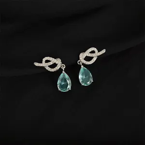 Detail view of crystal knot drop earrings with light blue gem closeup feature elegance.