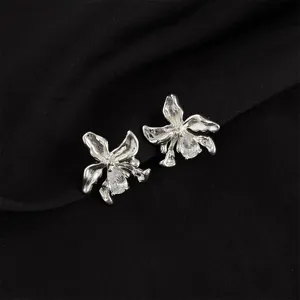 Detailed view of silver metallic orchid clip-on earrings with sparkling pear-shaped cubic zirconia.