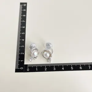 Chic baroque pearl clip-on earrings with shimmering zirconia pendants and gold-plated finish.