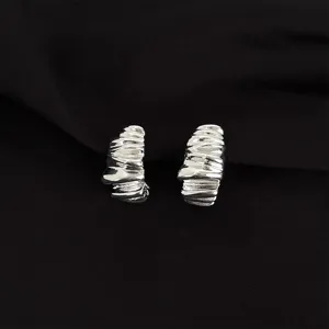 Detailed shot of abstract silver ear clips, unique sculpted design for non-pierced ears.